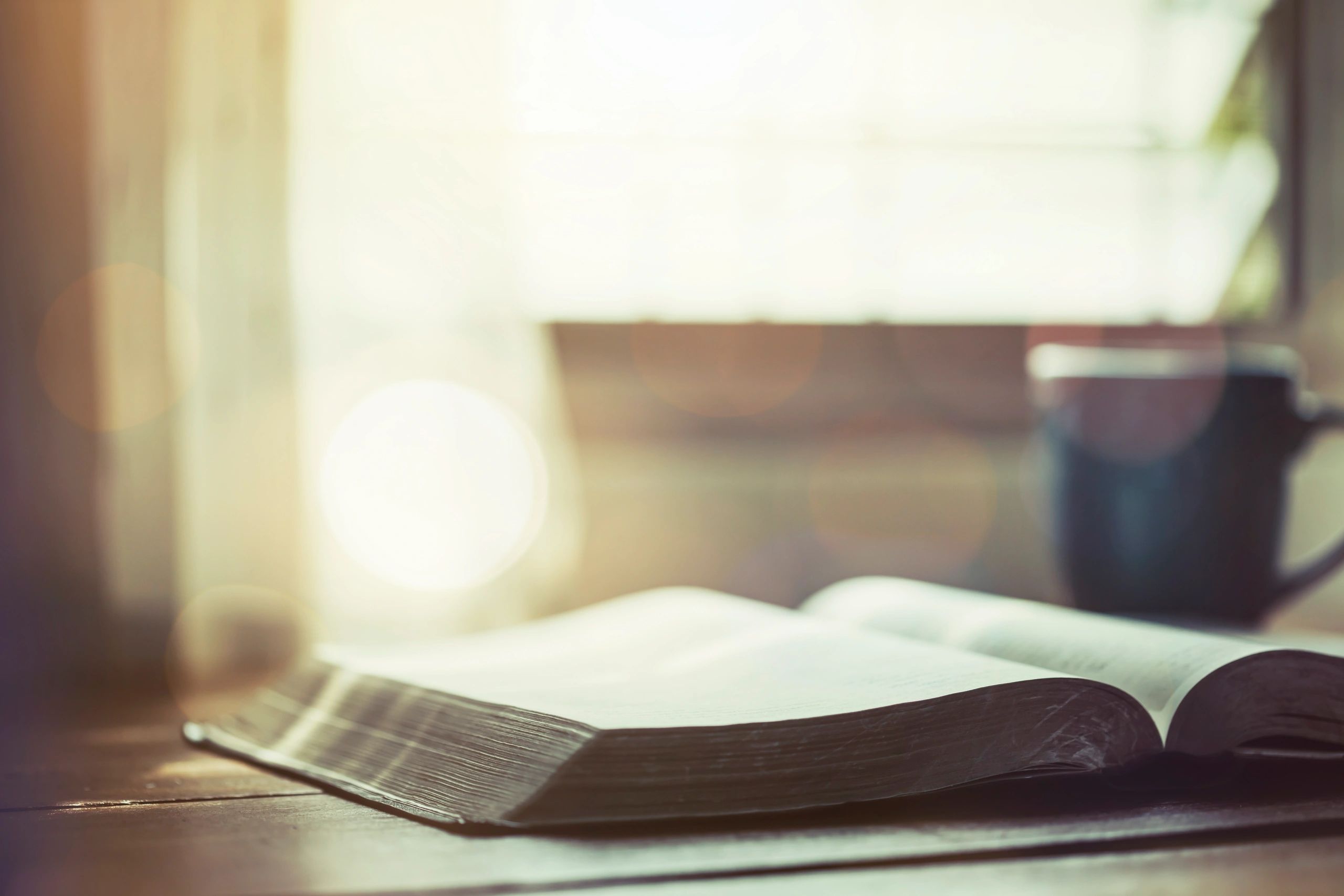Biblia abierta junto a una taza de café, concepto de devocional y reflexión