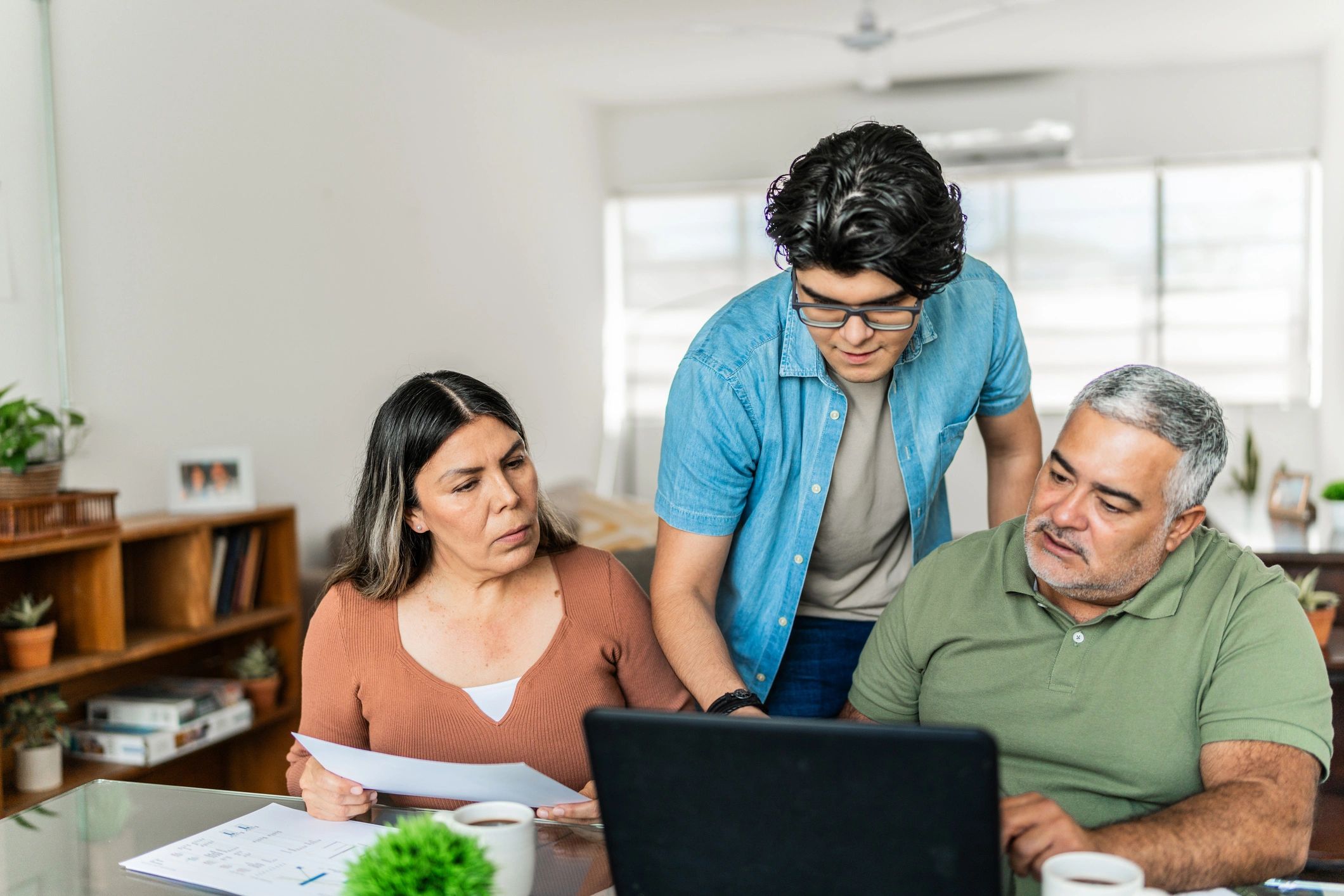 Familia revisando presupuesto en una laptop en casa