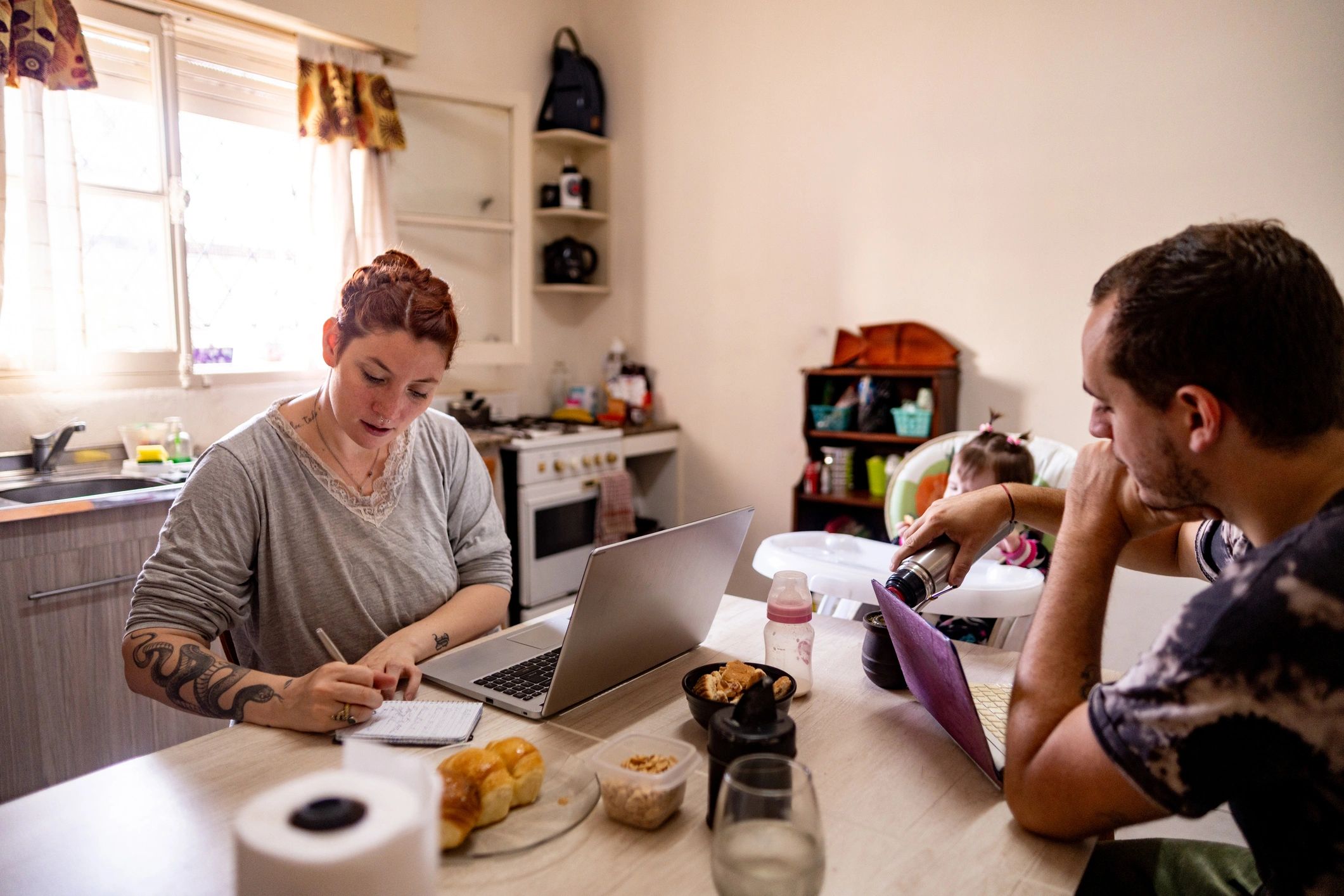Padres usando una laptop durante el desayuno en casa